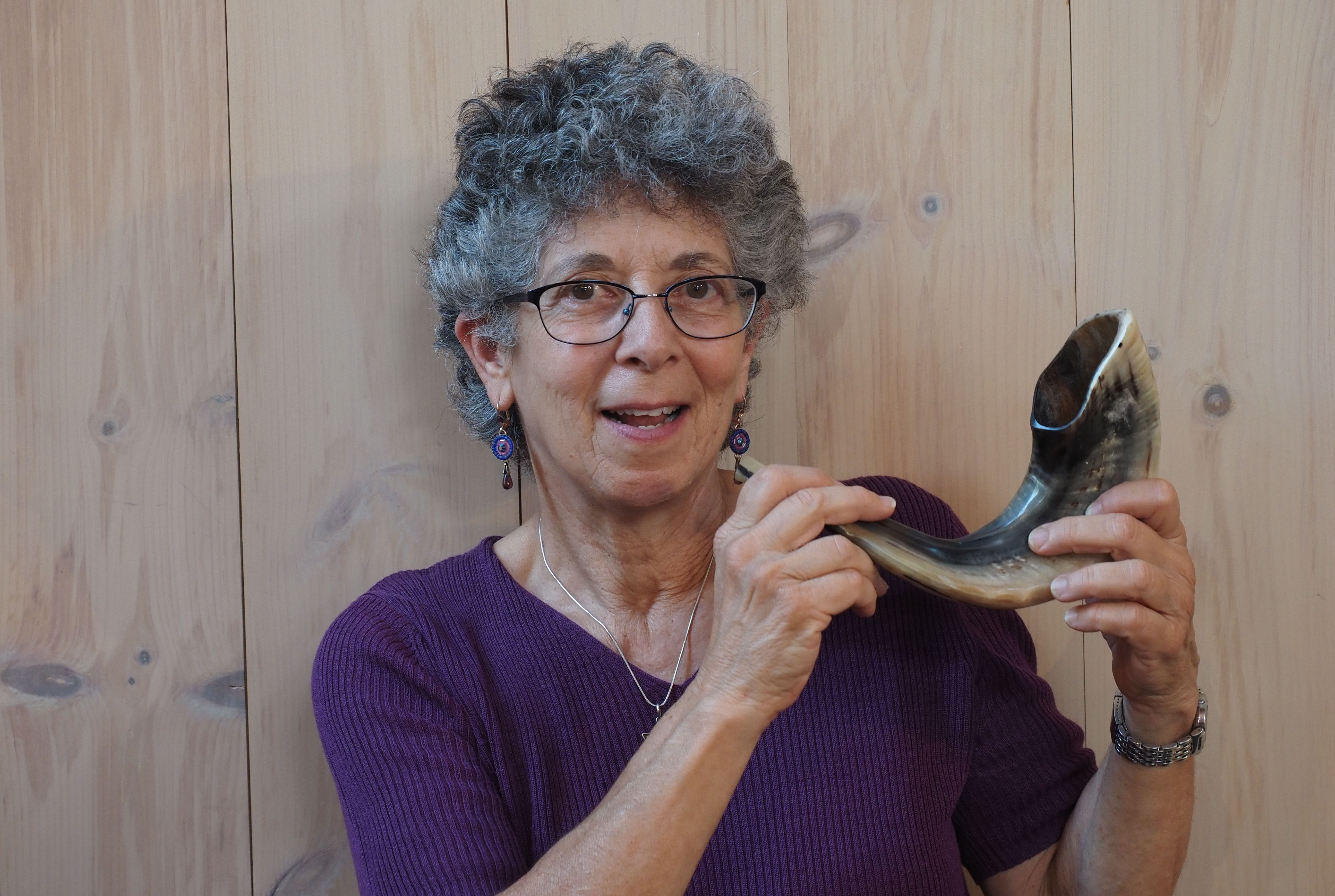 Suri smiling and holding a shofar